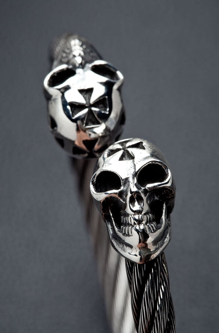 A close-up of the polished sterling silver skulls with cross details.