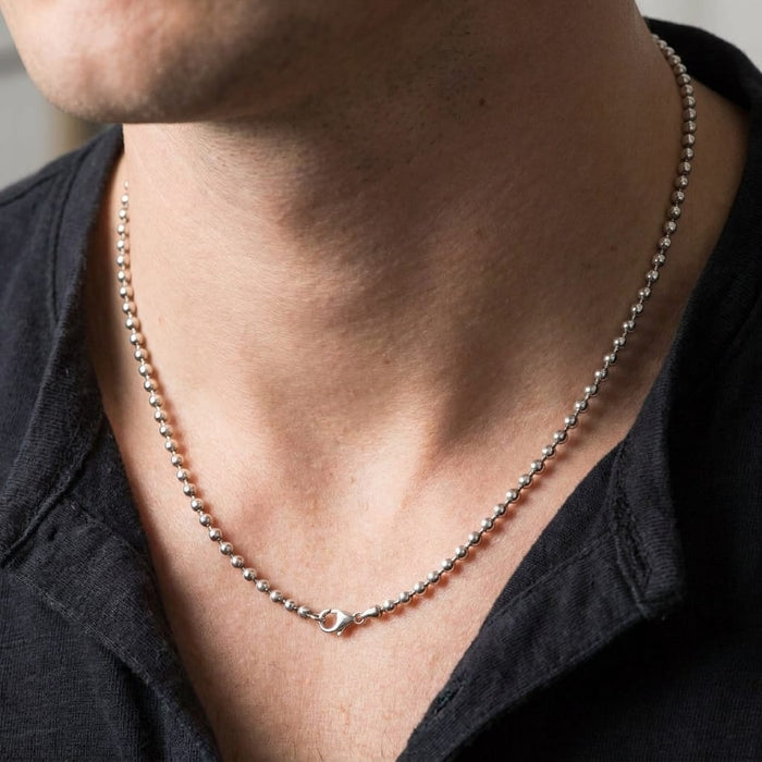 Close-up of a man wearing a 3mm sterling silver ball chain necklace with a black shirt.
