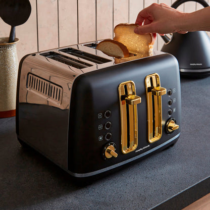 Black toaster with gold accents being used to toast bread on a kitchen counter.