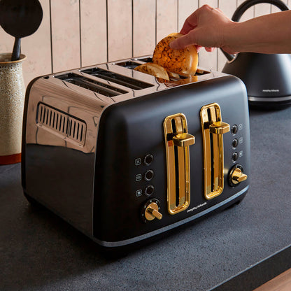 Black toaster with gold accents being used in a kitchen setting