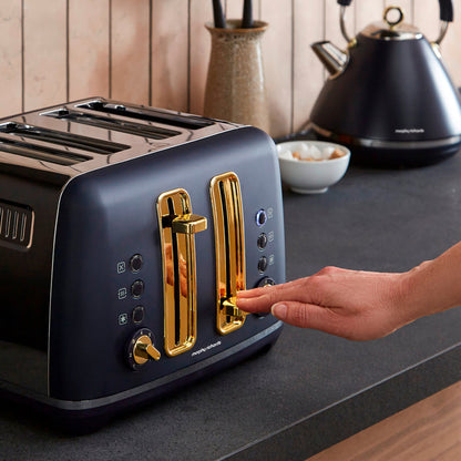 Blue toaster with gold accents on a kitchen counter, being operated by a hand.