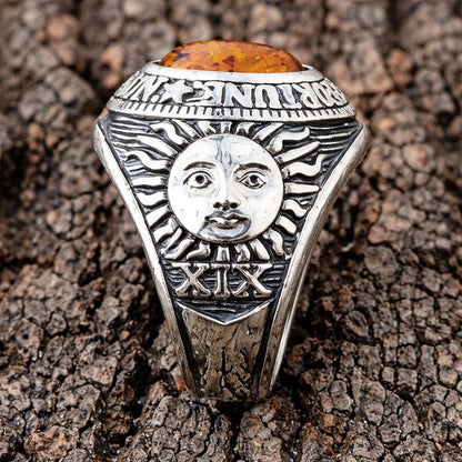 An side view of the Wheel of Fortune ring, with a clear focus on the polished carving of 'The Sun' on the band.