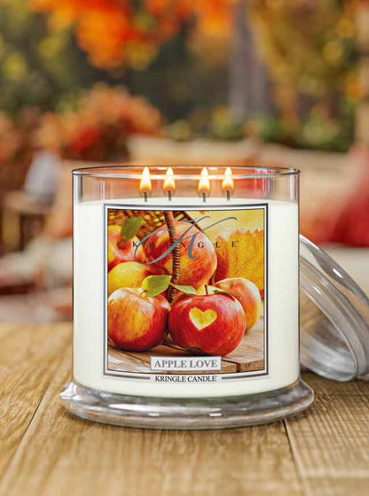 Kringle Candle 4-wick with 'Apple Love' label on a wooden surface with blurred background