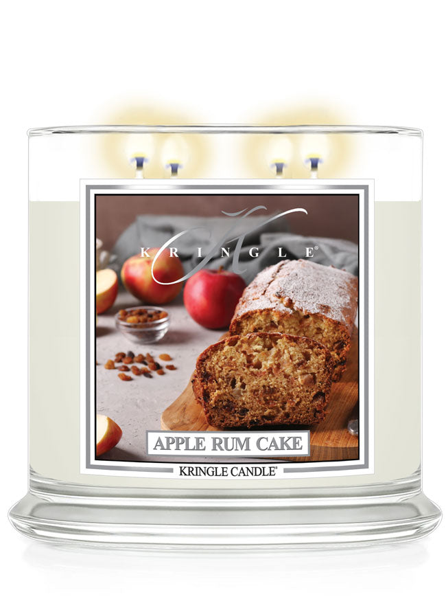 Lit XL 4-Wick candle labeled "Apple Rum Cake" with an image of sliced apple cake, apples, and spices.
