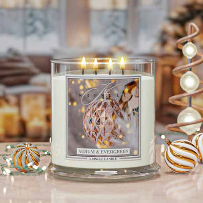 Aurum and Evergreen Lit candle with a decorative holiday label in a festive setting