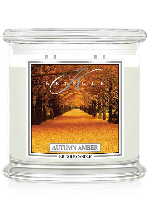 Kringle Candle Autumn Amber 4-wick candle with an autumn scenic label of trees and fall leaves