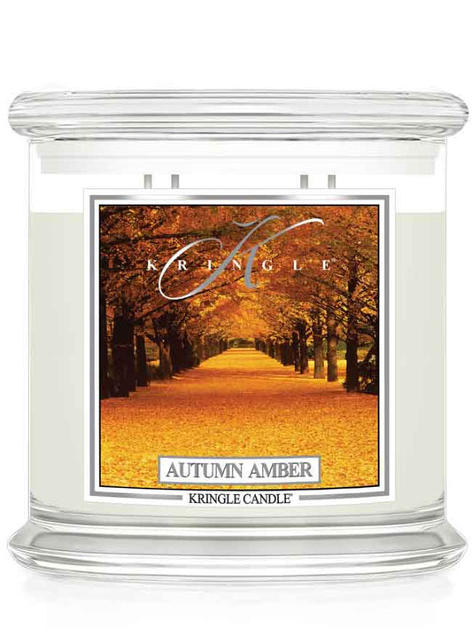 Kringle Candle Autumn Amber 4-wick candle with an autumn scenic label of trees and fall leaves