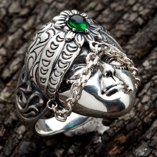A sterling silver ring featuring a detailed Bali tribal face with an ornate turban and a green stone.