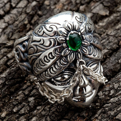 An ornate turban ring with a central emerald green stone, showcasing detailed Balinese-style carving.