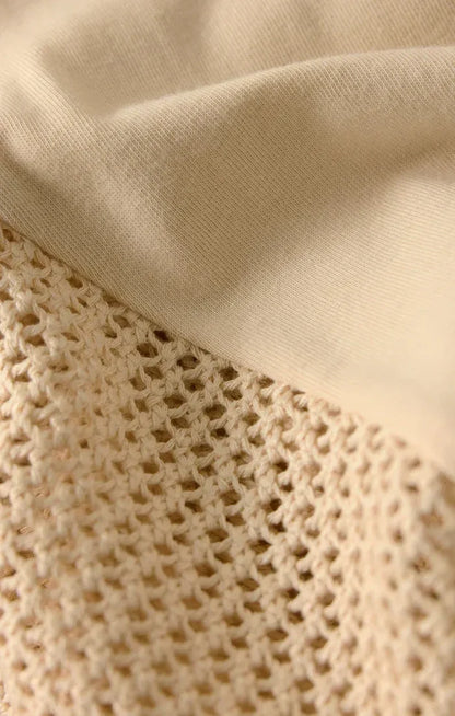 Cream-colored knit fabric with delicate openwork pattern on banyan crochet relaxed pants made of breathable crochet material
