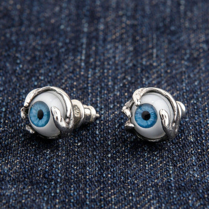 An angled view of the 10mm gothic eyeball claw stud earrings on a denim background.