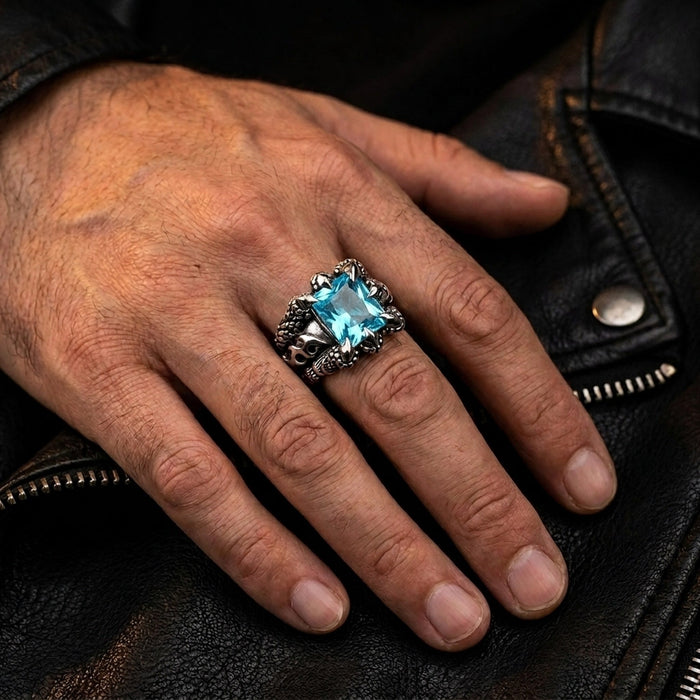 Worn on a man's hand against a black leather jacket, the blue topaz eagle claw ring in daily context