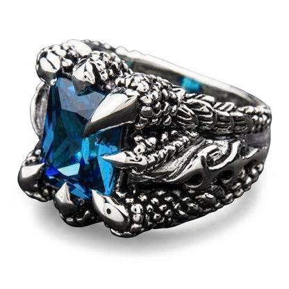 Three-quarter view showing the eagle talons and faceted blue topaz catching teal and sky-blue light