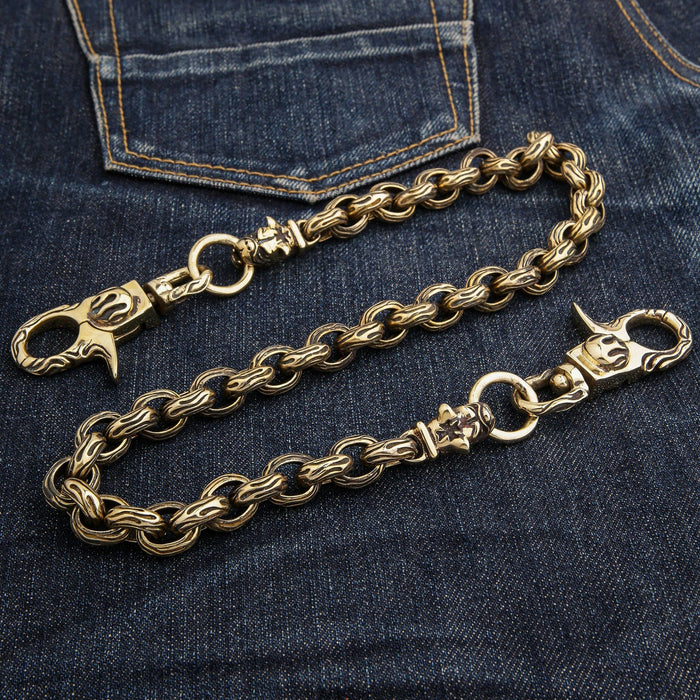 The heavy 207-gram brass wallet chain with bulldog heads laid out on a pair of denim