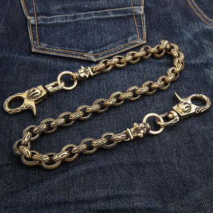 The heavy 207-gram brass wallet chain with bulldog heads laid out on a pair of denim