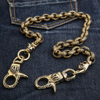 A detailed shot of the flame-engraved lobster clasps and bulldog connectors on the brass wallet chain.