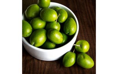 Bright green Castelvetrano olives from Italy in a white bowl.