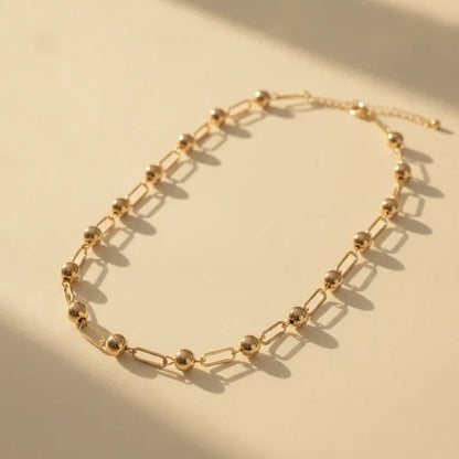 Chic minimalist gold ball and bar link chain necklace featuring gold-toned spherical beads and rectangular links