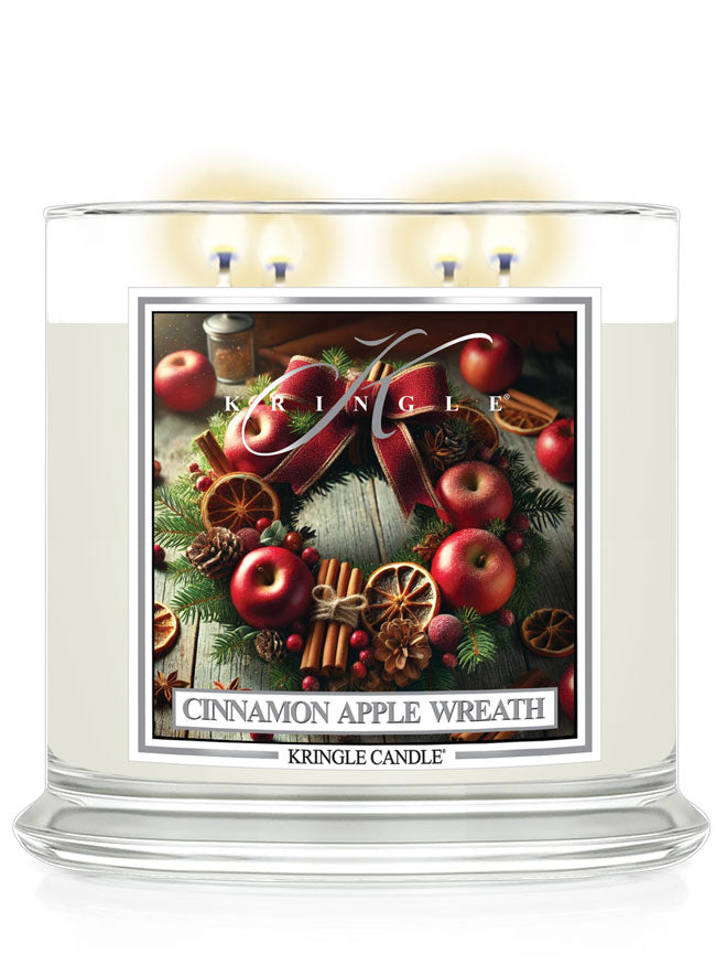4-wick candle with a Cinnamon Apple Wreath label, featuring apples, cinnamon sticks, and greenery, by Kringle Candle.