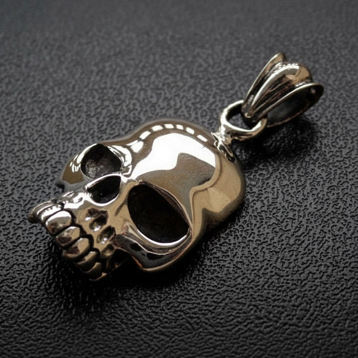 An angled view of the classic biker skull pendant in polished sterling silver.