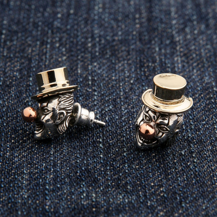 An angled shot of the men's clown stud earrings, showcasing the detailed carving and tri-metal design.