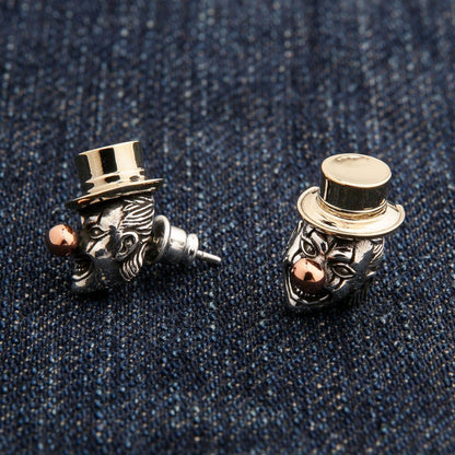 An angled shot of the men's clown stud earrings, showcasing the detailed carving and tri-metal design.