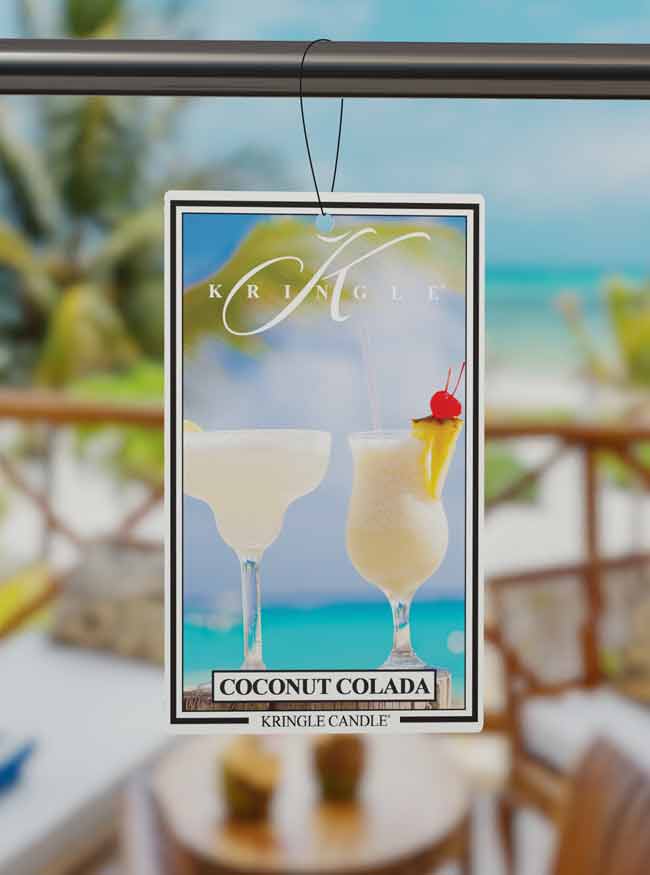 Kringle Candle Coconut Colada air freshener hanging in a room with blurred background