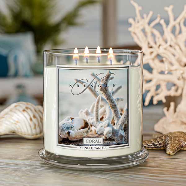 Kringle Candle with coral design 4-wick candle on a table with decorative items