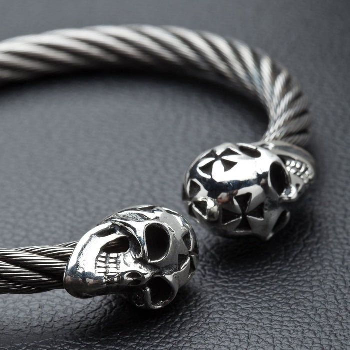 A close-up of the sterling silver skulls on the twisted stainless steel cable cuff bracelet.