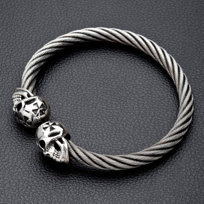 Angled view of the men's skull cuff bracelet on a black leather surface.