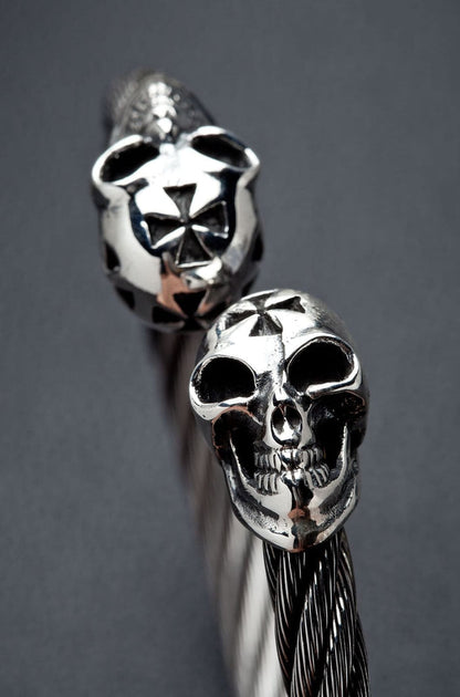 A close-up of the polished sterling silver skulls with cross details.