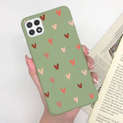 a woman holding a book and a phone case