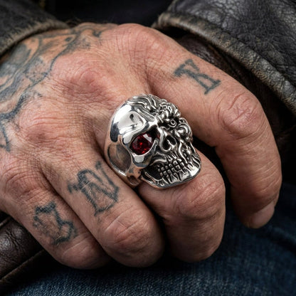 Sterling silver terminator skull ring worn on tattooed male hand with leather jacket showing ruby eye detail