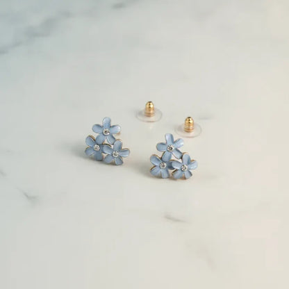 Dainty blue floral enamel stud earrings with clear crystal centers and gold-tone posts for elegant wear