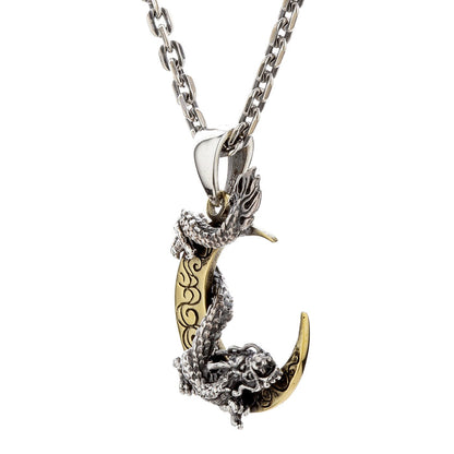 A side profile of the Eastern dragon pendant as it wraps around the brass moon.