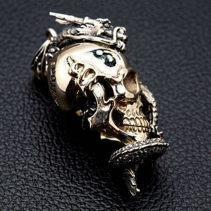Side profile of sterling silver dragon and brass skull pendant with sculpted depth