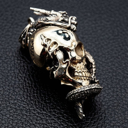 Side profile of sterling silver dragon and brass skull pendant with sculpted depth