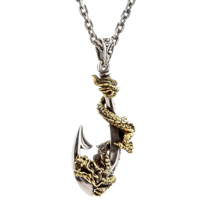 An angled view of the two-tone dragon fish hook pendant, showing the brass dragon on the silver hook.