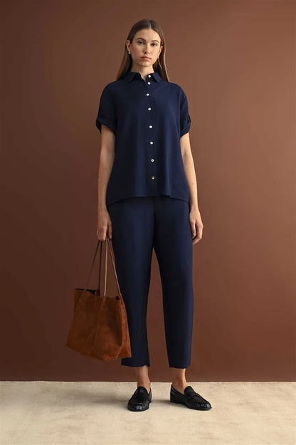 Navy blue short-sleeved button-up shirt with rolled cuffs and classic collar paired with elastic waist crop pants