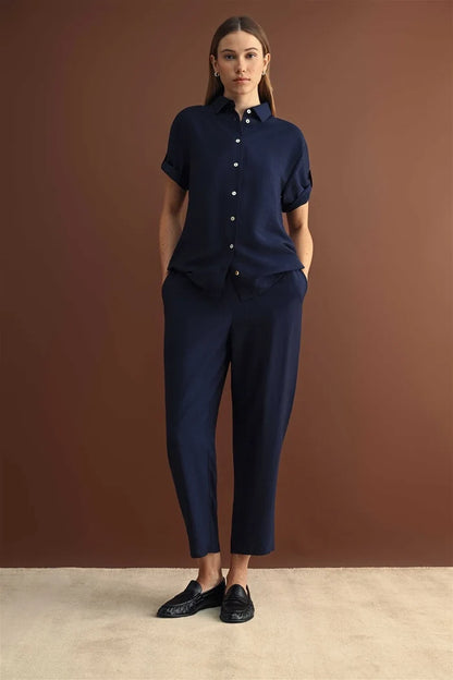 Navy blue short-sleeved button-down shirt with rolled cuffs paired with elastic waist crop navy trousers