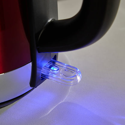 Close-up of a red electric kettle with a blue light on a white surface