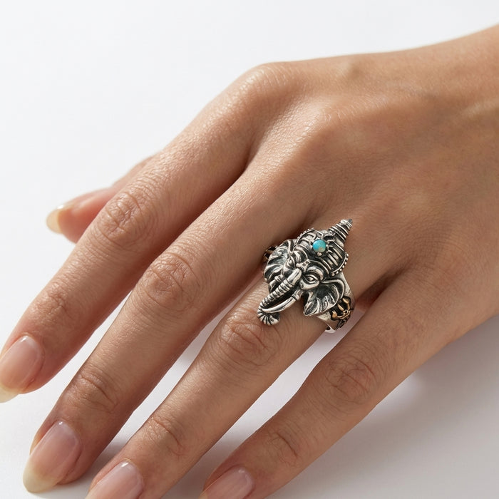 Sterling silver Ganesh elephant head adjustable ring with turquoise stone accent worn on a woman's ring finger, featuring intricate detailed craftsmanship in vintage oxidized silver style
