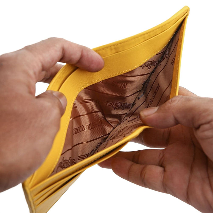 A handcrafted yellow wallet held open to show the silk-lined bill compartment.