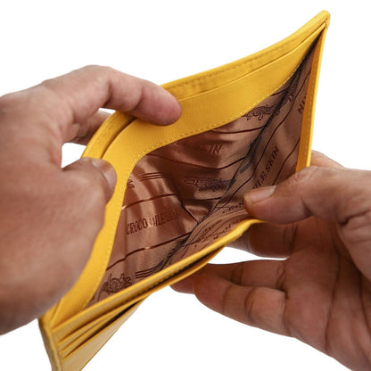 A handcrafted yellow wallet held open to show the silk-lined bill compartment.