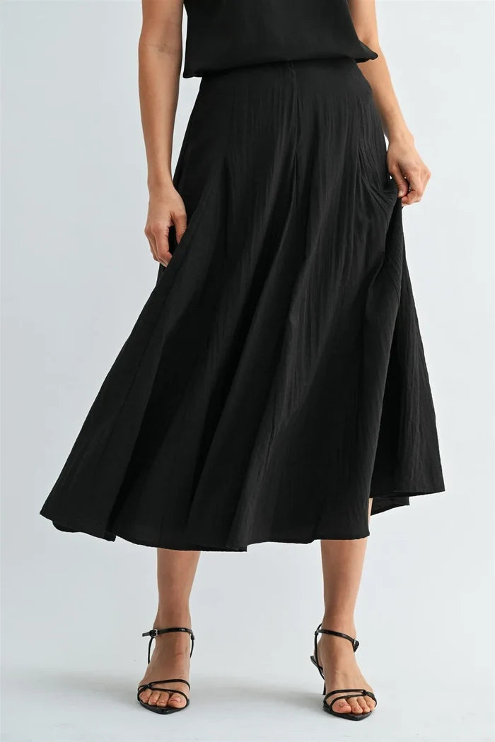Black godet midi skirt with pleats and flowing asymmetrical hemline featuring a side zipper closure