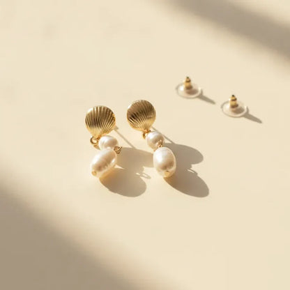 Gold seashell pearl drop earrings featuring a double pearl drop design in gold-toned metal for elegant wear