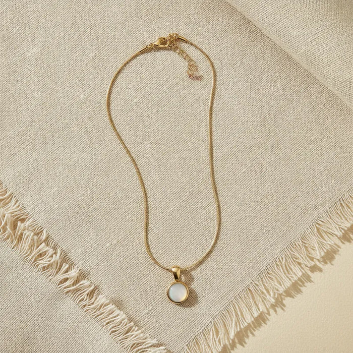 Gold snake chain necklace with a delicate gold snake chain and round white mother of pearl pendant