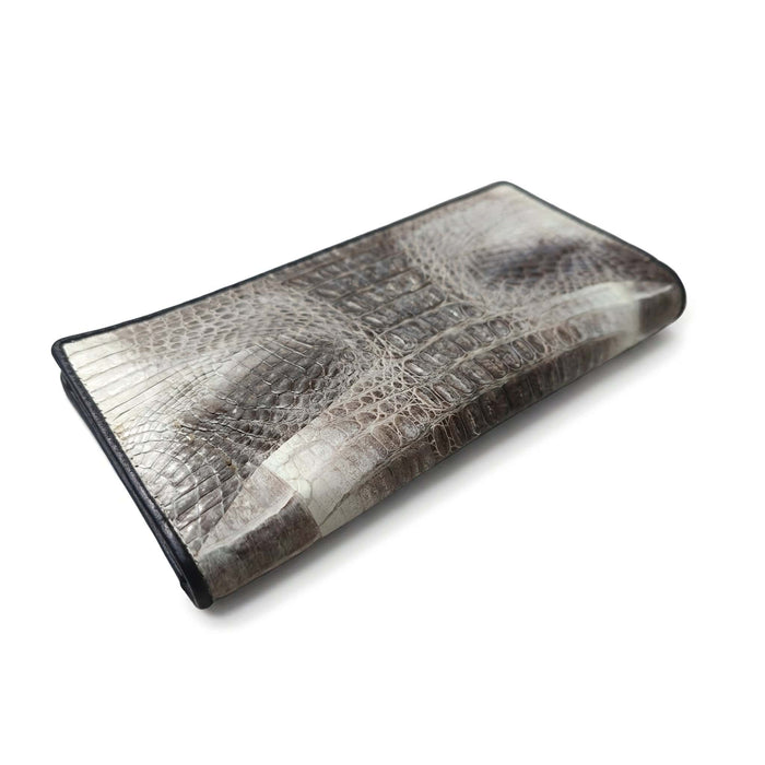 Tail crocodile skin wallet at three-quarter angle, revealing dimensional scale texture and black leather trim.
