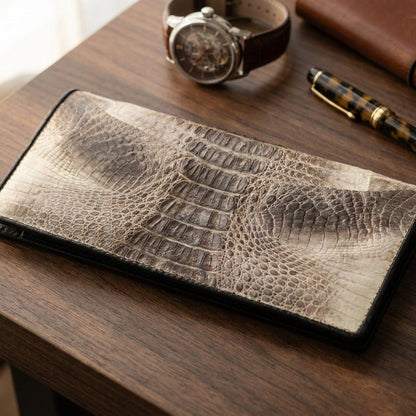 Luxury desk scene featuring tail crocodile wallet with leather-strap watch, fountain pen, and notebook.