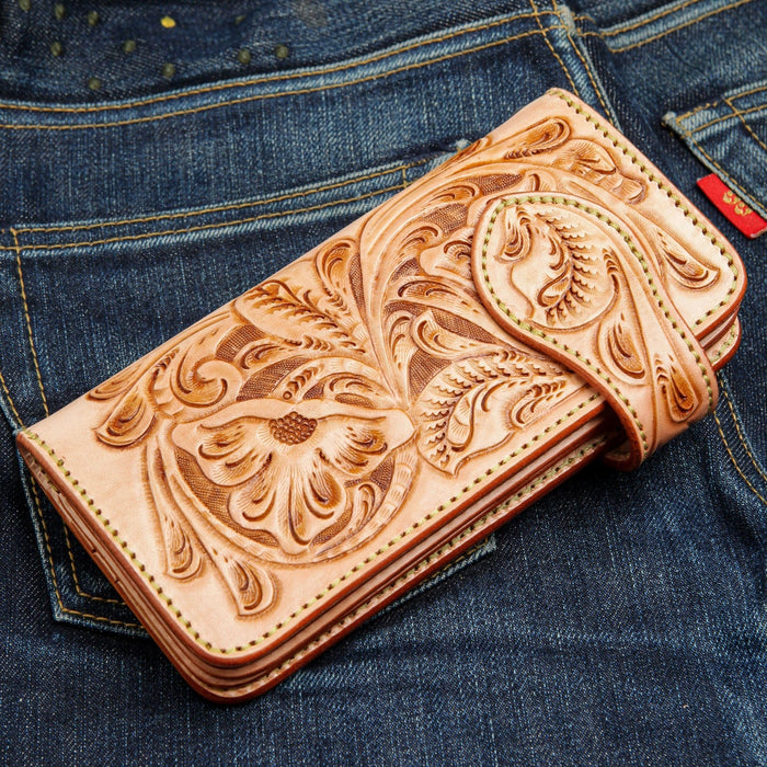 A close-up of the hand-tooled leather strap and floral carving.